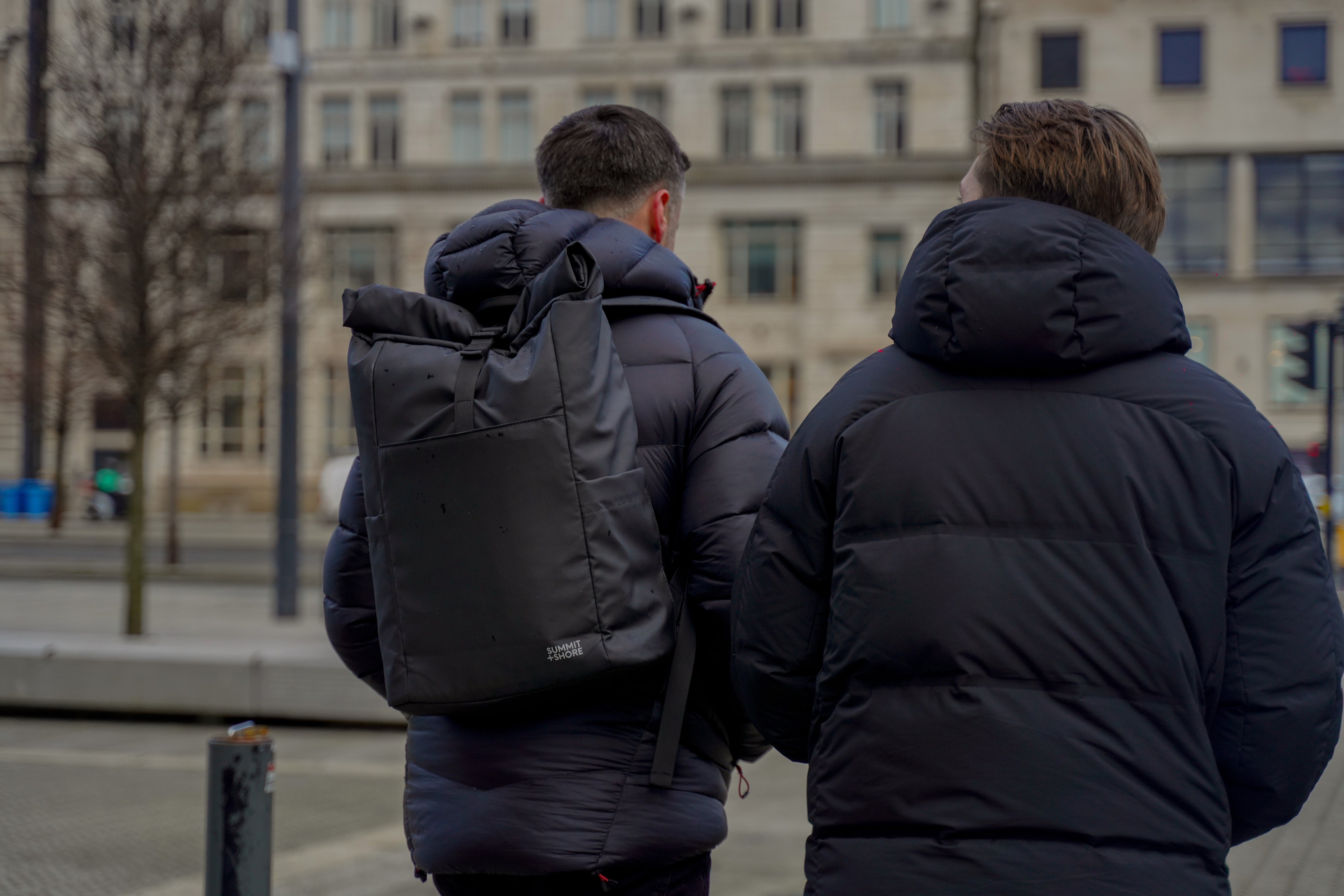 Two Men Walking Through City with Summit and Shore Roll Top Backpack